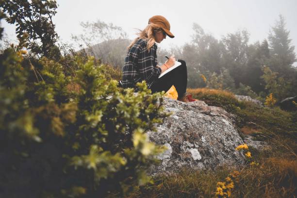 woman journaling in the woods