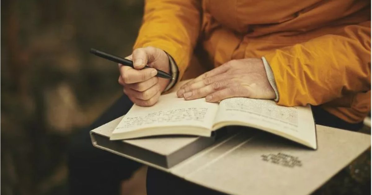woman journaling in the woods
